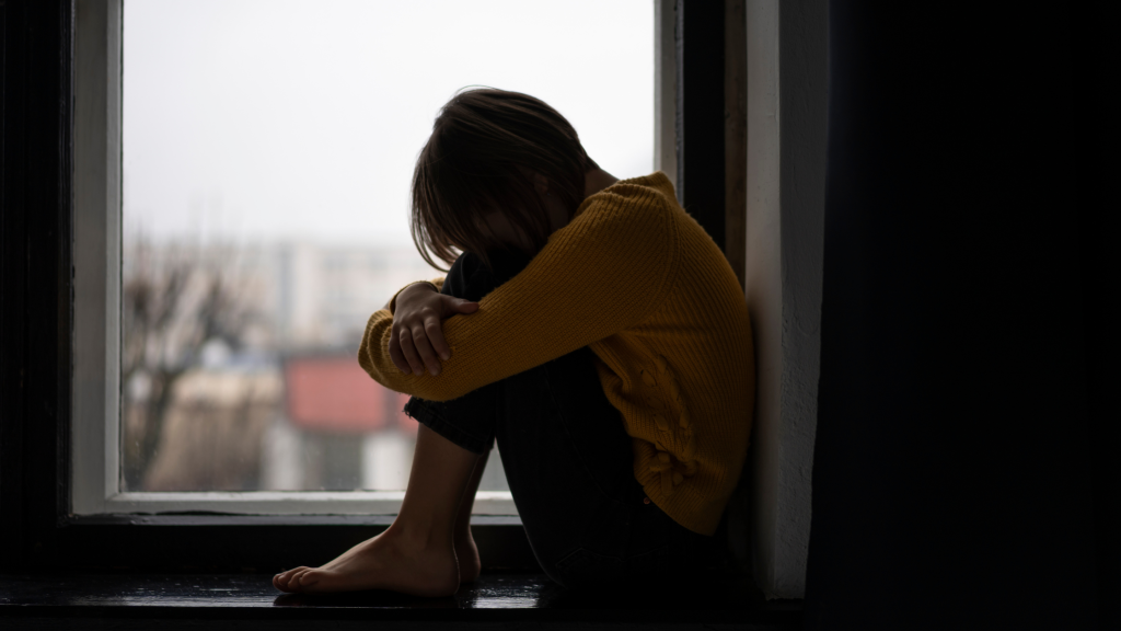 síntomas de la depresión: mujer pensativa junto a una ventana